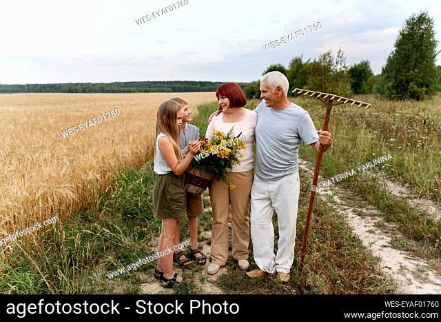 Grandparent and children with tansy flowers at field