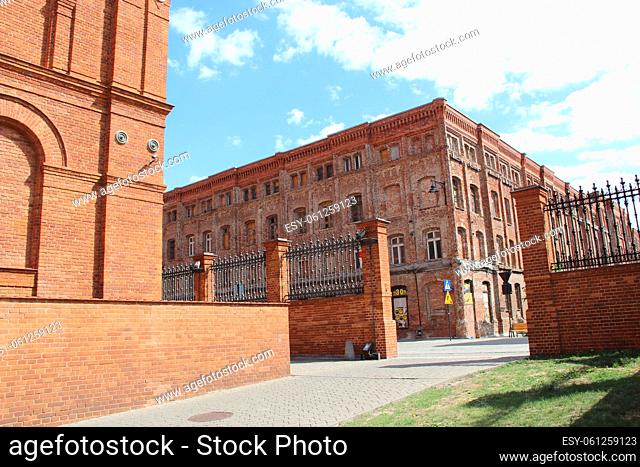 Facade of red brick factory building. Facade of old brick building. Old factory building with windows in Polish city of Lodz