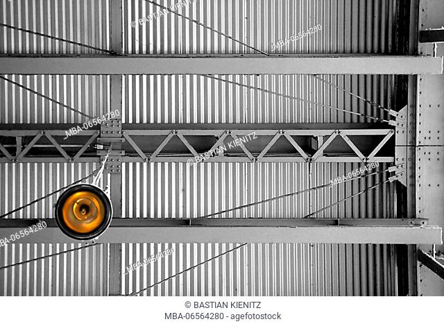 Photography of a roof of corrugated iron with a lamp and steel girders