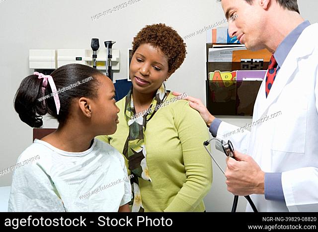 Doctor reassuring mother and daughter