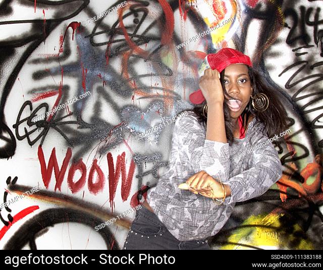 Black woman dancing near graffitied wall
