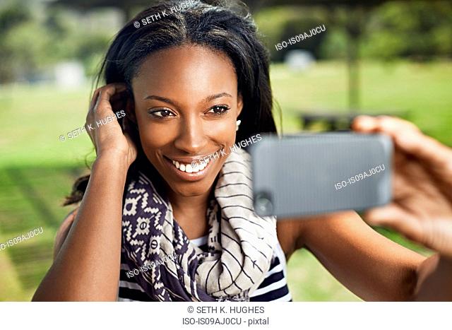 Young woman taking self portrait on smartphone
