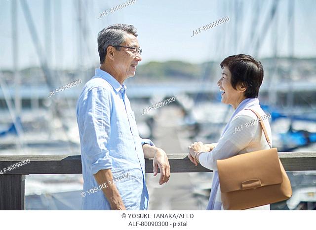 Japanese senior couple having fun by the sea