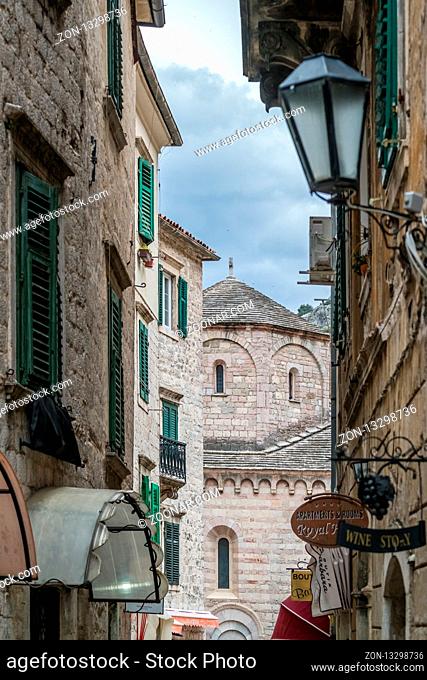 Kotor, Montenegro - April 2018 : Dome of an old church seen from between narrow passage between historical residential buildings in the Kotor Old Town