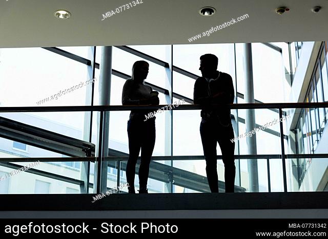 Young woman and young man in modern office building make break