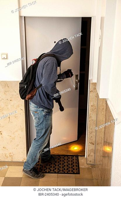 Burglar prying open an apartment door