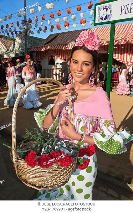 April Fair, Girl wearing a traditional gypsy dress with basket of flowers, Seville, Spain
