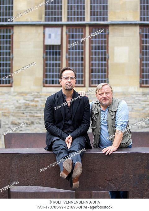 The actors Jan Josef Liefers (L) and Axel Prahl pose on the two benches by artist Eduardo Chillida during the shooting of the new 'Tatort' from Muenster