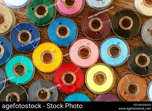 Close-up on colored sewing threads on spools. Top view