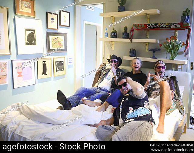 14 November 2023, Hamburg: Presenter Barbara Schöneberger (M) and friends lie on a bed in a suite she designed during a media tour of the new ""Villa Viva...