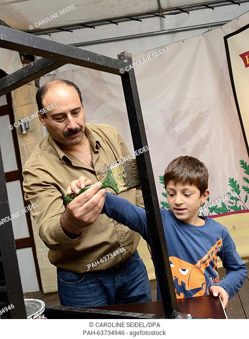 Gabro Barsoum (l) from Syria and his son Jak varnish tables in the festival tent of the local marksmenship marksmenship association 'Paderborner...