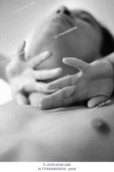 Woman with backs of hands on neck, close-up, black and white