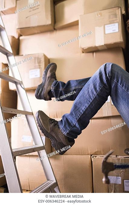 Worker falling off ladder in warehouse