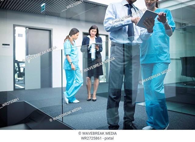 Doctors and nurses discussing over digital tablet