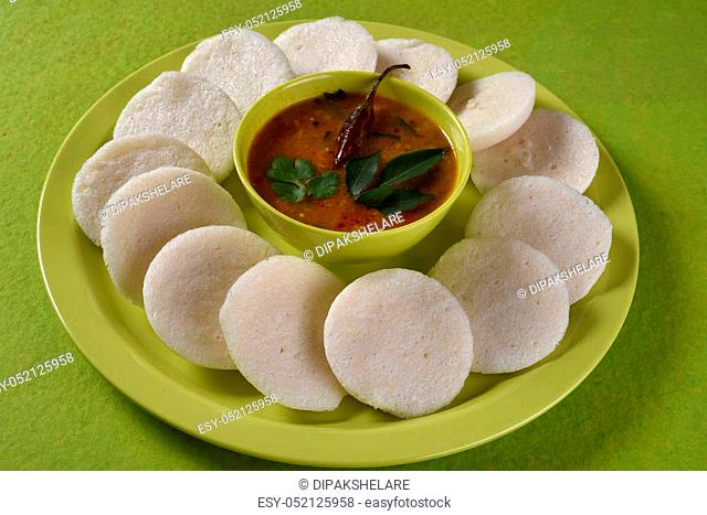 Idli with Sambar in bowl on green background, Indian Dish: south Indian favourite food rava idli or semolina idly or rava idly