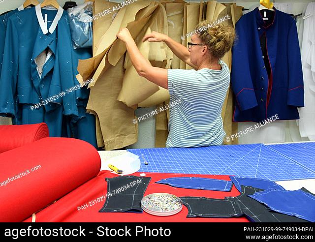 24 October 2023, Thuringia, Altenburg: At Hut und Kostüm GmbH, ladies' tailor Peggy Zimny prepares fabric parts for a uniform