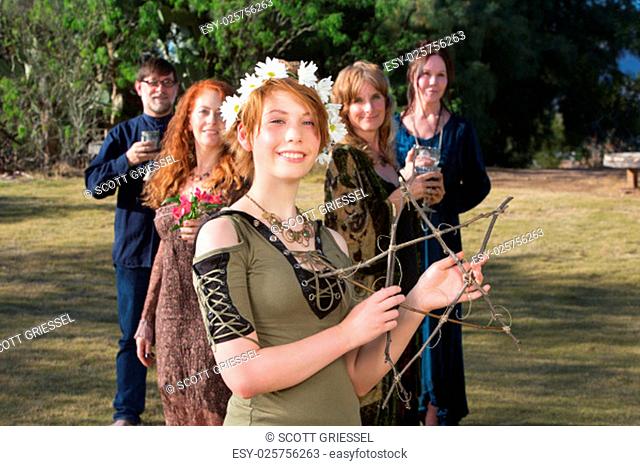 Young pagan woman with group holding a stick pentagram