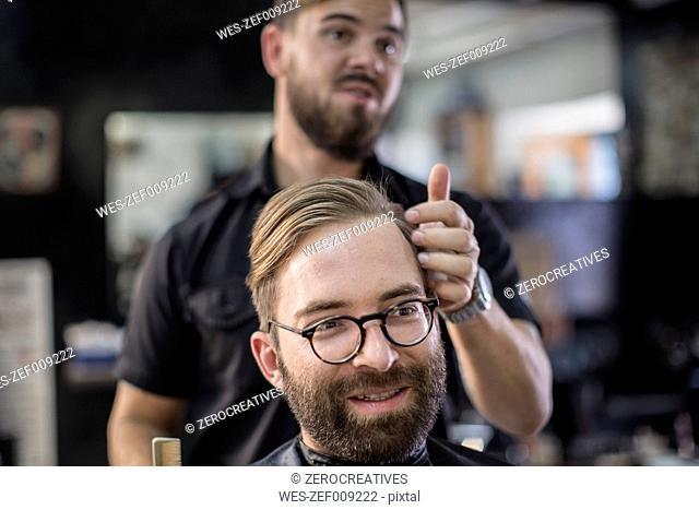 Barber and customer, smiling