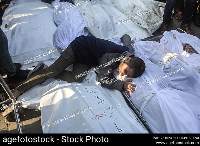24 October 2023, Palestinian Territories, Khan Yunis: A Palestinian grieves beside the bodies of members of the Saqallah family