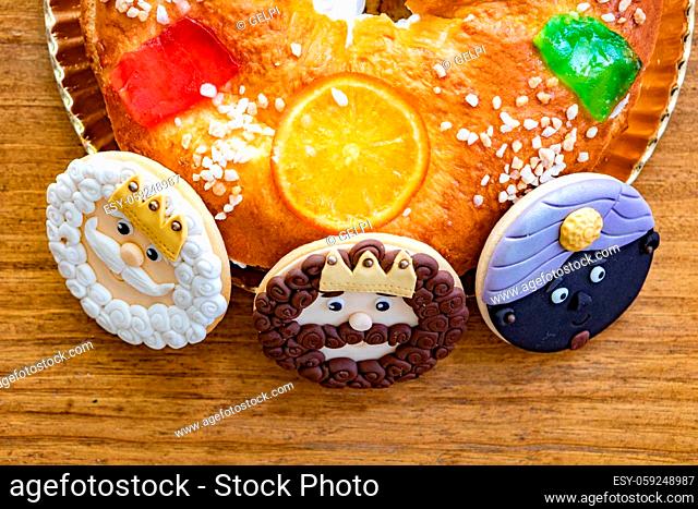 Cookies of The three Wise Man next to a delicious Spanish Christmas cake on a wooden background