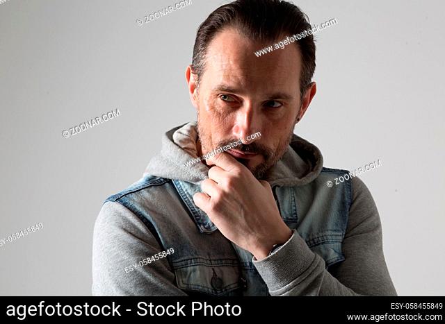 Dark haired and beard cool man looking thoughtfully and directly
