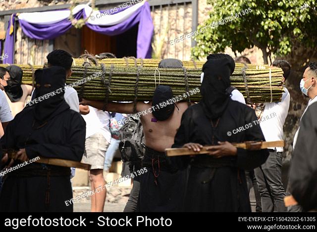 TAXCO, MEXICO - APR 15, 2022: A woman penitent wears a black hood known as a capirotte and a black robe, while takes part during Good Friday of the Holy Week...