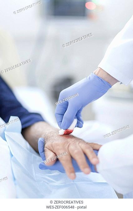 Nurse cleaning patient hand from IV drip