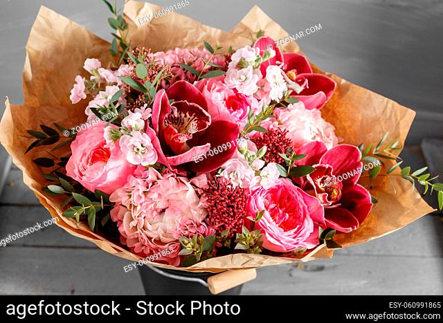 Bouquet of pink roses and Other colors flowers on wooden background, copy space
