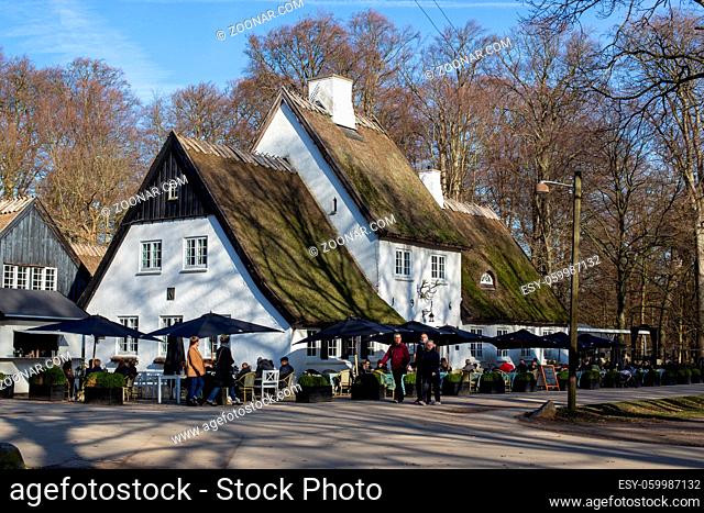 Klampenborg, Denmark - February 16, 2019: People sitting in the outdoor area of restaurant Peter Lieps Hus situated in the Deer Park Dyrehaven