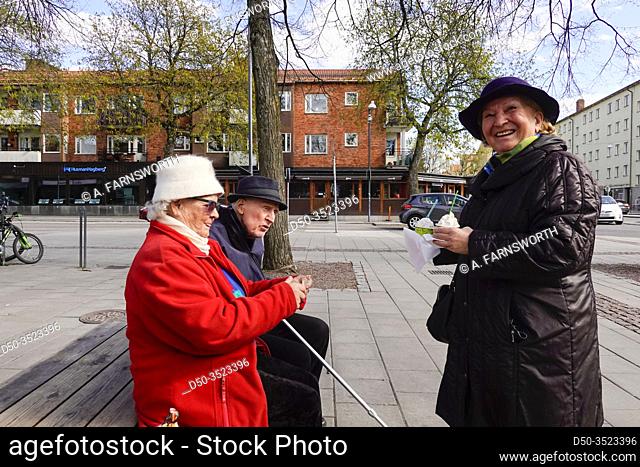 Stockholm, Sweden Three seniors enyoing ice cream on a Sunday afternoon on the square in the Arsta suburb