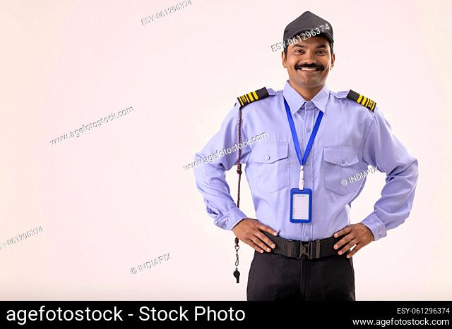 Portrait of Security guard standing with hands on waist