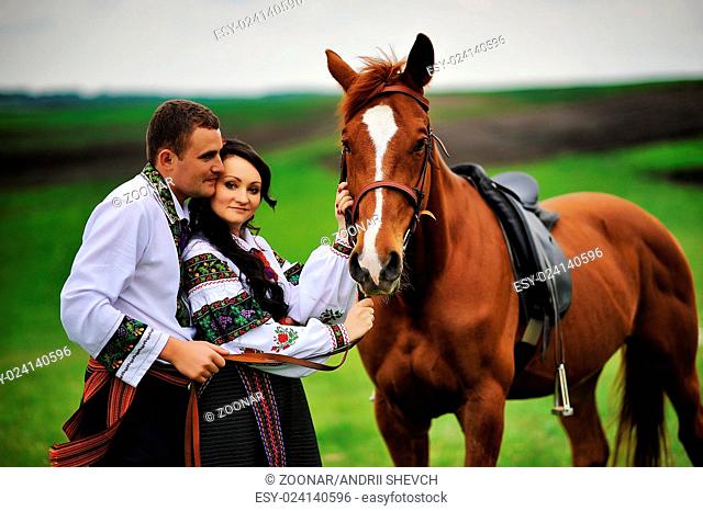 Young couple on national dress with horses