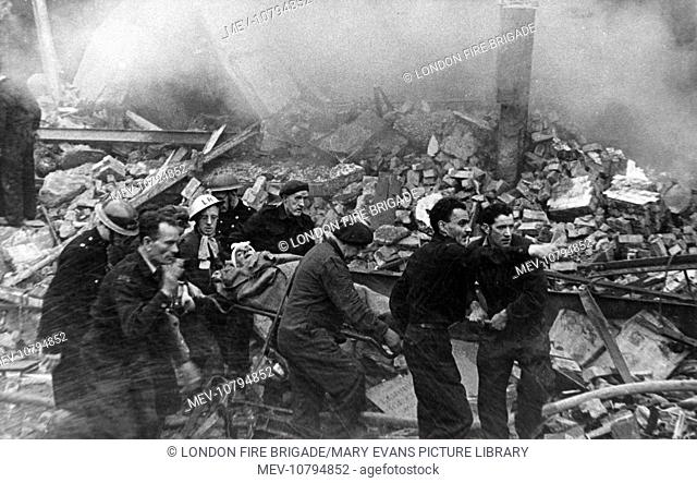 Blitz in London -- a casualty who has just been rescued from the rubble is carried on a stretcher to an ambulance.  (3 of 3)