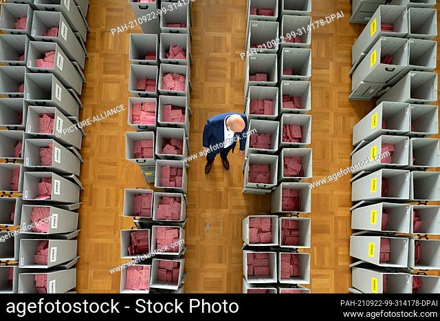 22 September 2021, Saxony, Dresden: Markus Blocher, district election officer, inspects numerous ballot boxes filled with ballot paper envelopes for the postal...