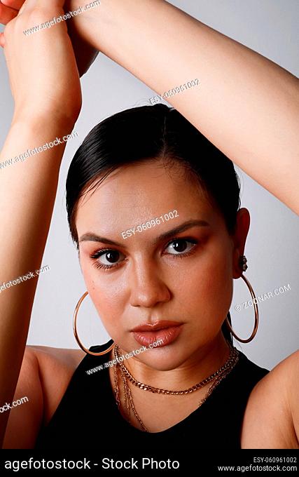 Close-up of attractive brunette young woman, posing over white background wall. High quality photo