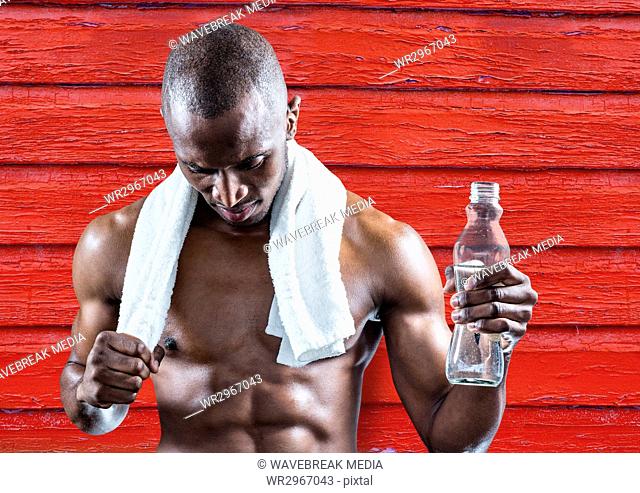fitness man with water and towel with red wood background