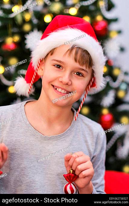 Cute funny baby with Christmas decorations on his ears and in his hands. Christmas happiness