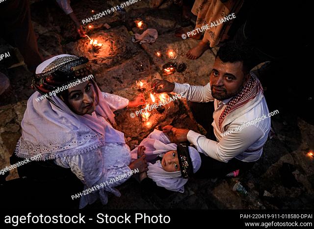 19 April 2022, Iraq, Dohuk: Iraqi Yazidis light candles and torches at the Lalish mountain valley and temple, the holiest shrine of the Yazidis
