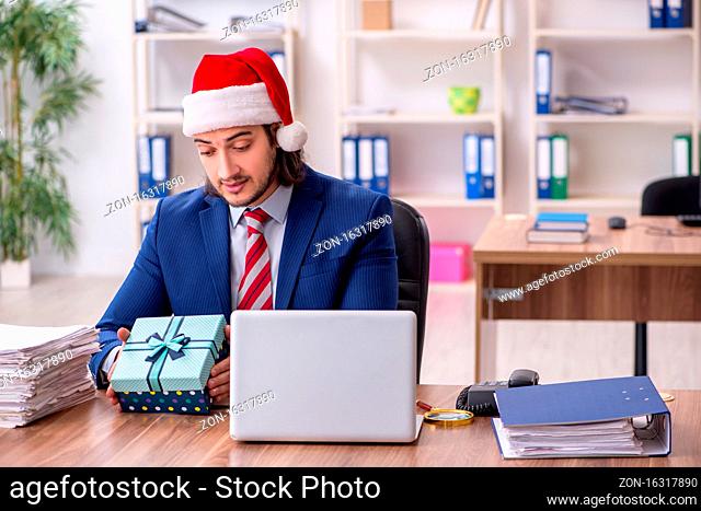 Young employee working in the office at Christmas Eve