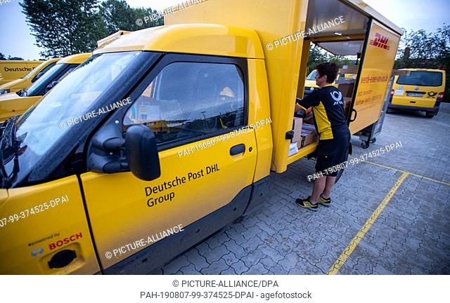 07 August 2019, Mecklenburg-Western Pomerania, Wittenburg: Parcel carrier Ute Eissing loads the electrically driven transporter ""Streetscooter"" at Deutsche...