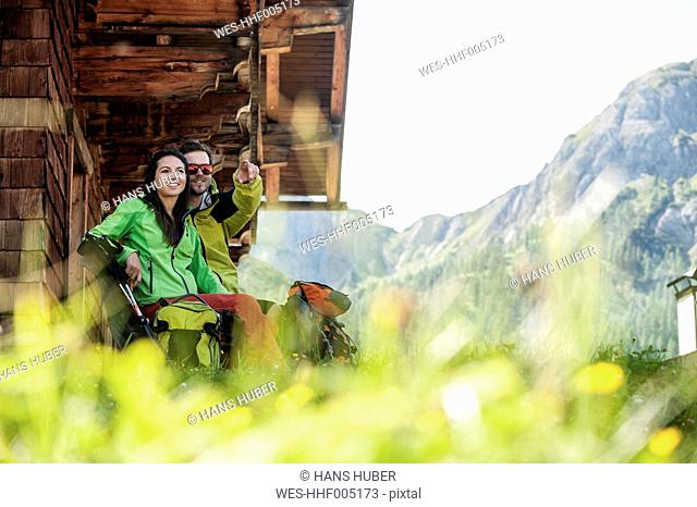 Austria, Altenmarkt-Zauchensee, young couple at alpine cabin