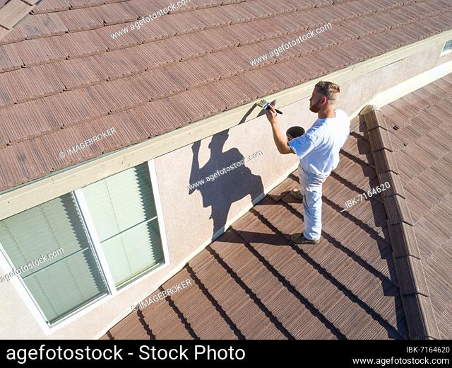 Professional painter using A brush to paint house facade