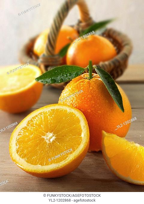 Fresh oranges whole and cut halves with leaves