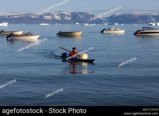 Man with kayak comming home to Qaanaaq, Greenland.