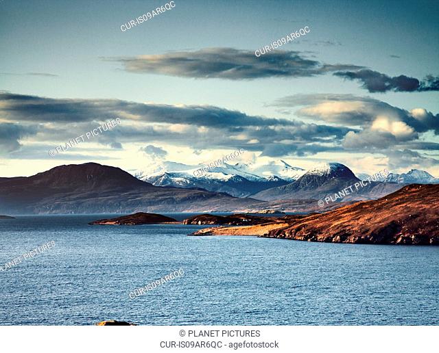 Lake surrounded by snow capped mountains, Assynt, Scotland