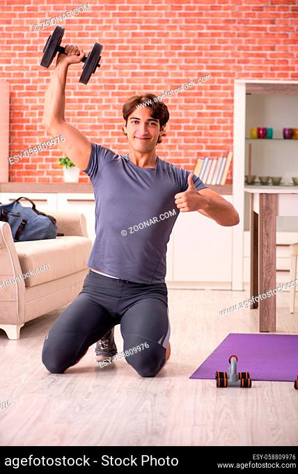 Young handsome man doing sport exercises at home