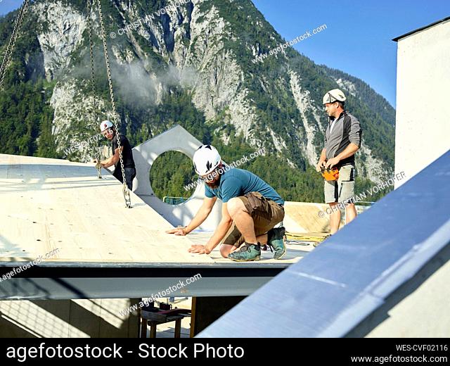 Carpenters installing roof at construction site