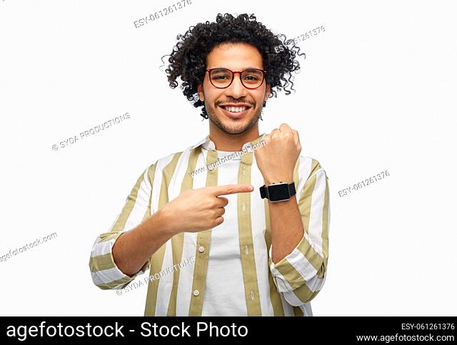 smiling young man in glasses showing smart watch