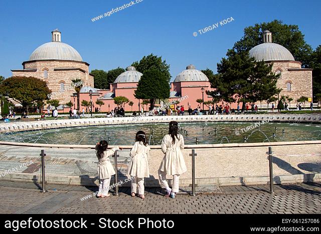 Three little girls by the pool with domes in Istanbul