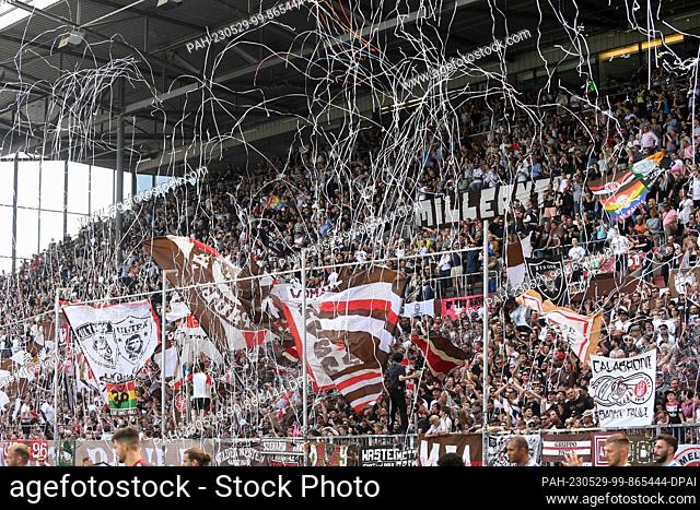 28 May 2023, Hamburg: Soccer, 2. Bundesliga, FC St. Pauli - Karlsruher SC, Matchday 34, Millerntor-Stadion. FC St. Pauli fans celebrate their team on the south...